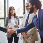 Two people shaking hands, representing a successful partnership between an employer and INZ after accreditation renewal.