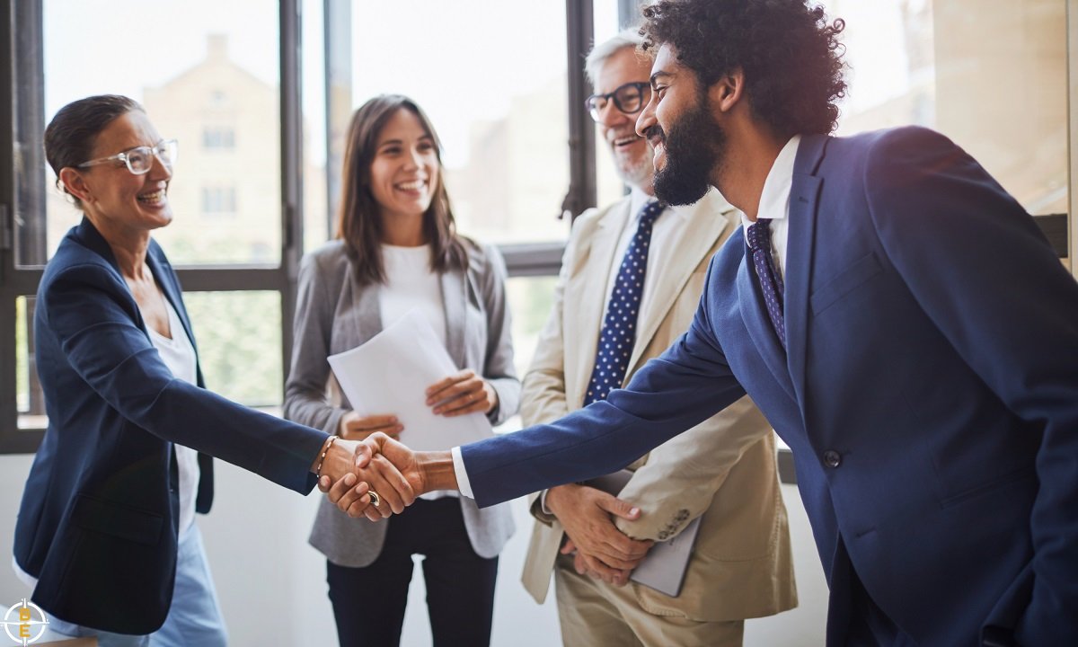 Two people shaking hands, representing a successful partnership between an employer and INZ after accreditation renewal.